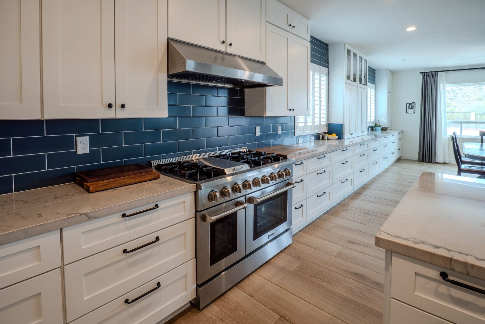White kitchen island with barstools and pendant lights