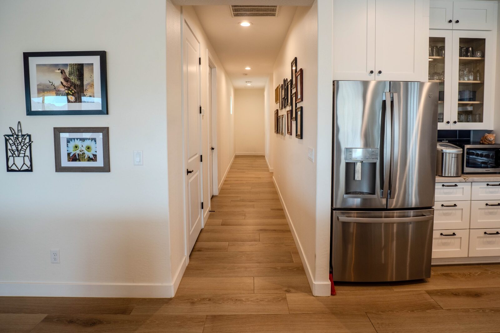 Hallway with gallery wall and stainless steel refrigerator