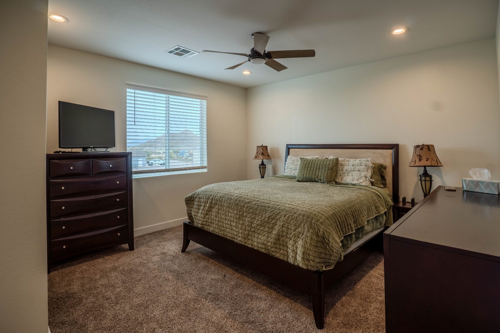 Bedroom with mountain view window and dark wood furniture