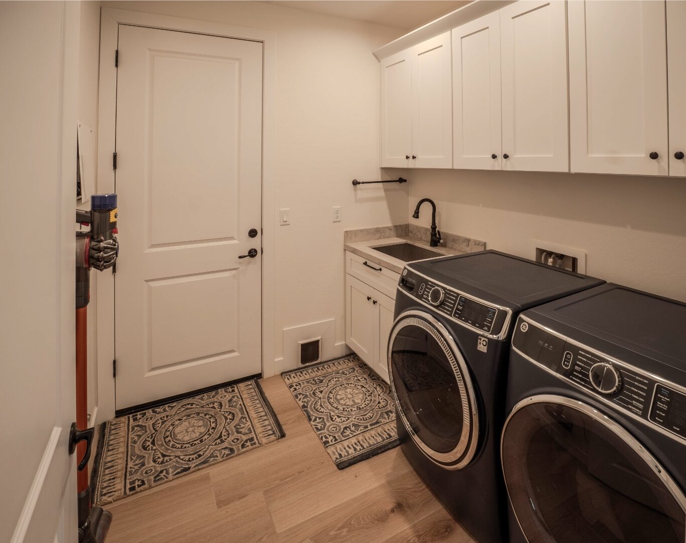 Laundry room with dark front-load washer and dryer